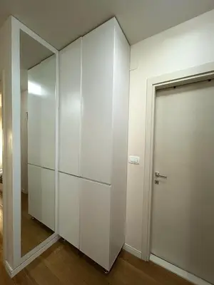 a white closet with a door and a mirror at Elegant apt in Central Point in Podgorica
