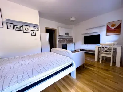 a bedroom with a bed and a living room at Pela's Apartment in Budva