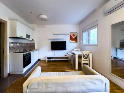 a living room with a white couch and a table at Pela's Apartment in Budva