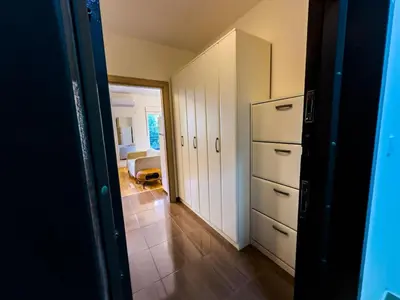a room with a hallway with a refrigerator and a bedroom at Pela's Apartment in Budva
