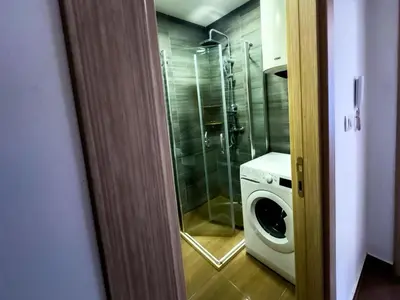 a bathroom with a shower and a washing machine at Pela's Apartment in Budva