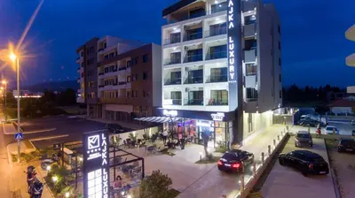 a building with cars parked outside of it at night at Hotel Lajka Luxury in Ulcinj