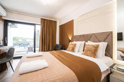 a hotel room with a large bed and a desk at Hotel Lajka Luxury in Ulcinj