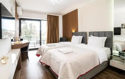 a hotel room with two beds and a desk at Hotel Lajka Luxury in Ulcinj