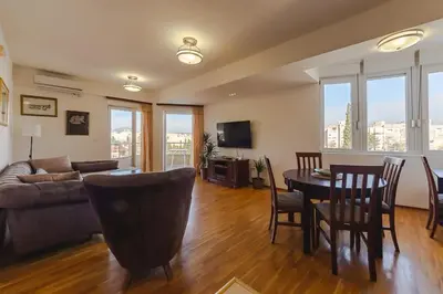 a living room with a couch and a table and chairs at Sunbright Metropolitan in Podgorica