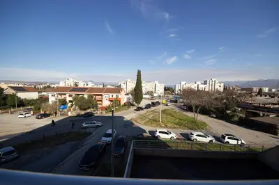 a city street with cars parked in a parking lot at Sunbright Metropolitan in Podgorica