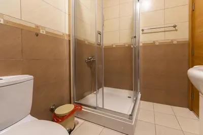 a bathroom with a shower with a toilet and a sink at Sunbright Metropolitan in Podgorica