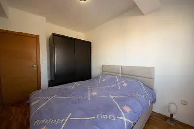 a bedroom with a bed with a blue comforter at Sunbright Metropolitan in Podgorica