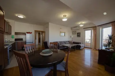 a kitchen and a living room with a table and chairs at Sunbright Metropolitan in Podgorica