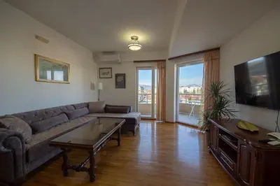 a living room with a couch and a tv at Sunbright Metropolitan in Podgorica