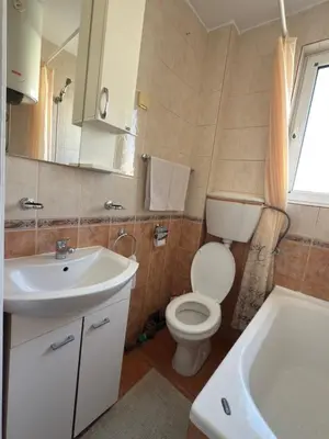 a bathroom with a toilet and a sink and a tub at Bar Central Stay Apartment in Bar
