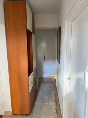 a hallway with a wooden cabinet and a door at Bar Central Stay Apartment in Bar