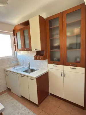 a kitchen with wooden cabinets and a sink at Bar Central Stay Apartment in Bar