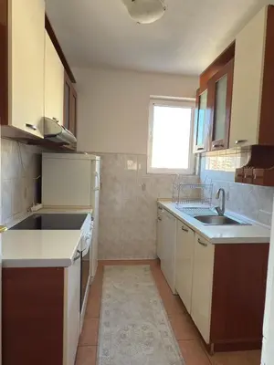 a kitchen with white cabinets and a sink and a window at Bar Central Stay Apartment in Bar
