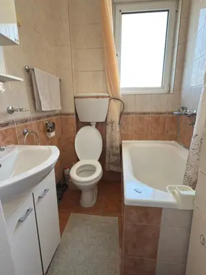 a bathroom with a toilet and a sink and a tub at Bar Central Stay Apartment in Bar