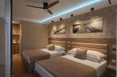 a hotel room with two beds and a ceiling fan at Resort Comfort - Long Beach in Ulcinj