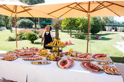 a woman standing in front of a table full of food at Resort Comfort - Long Beach in Ulcinj
