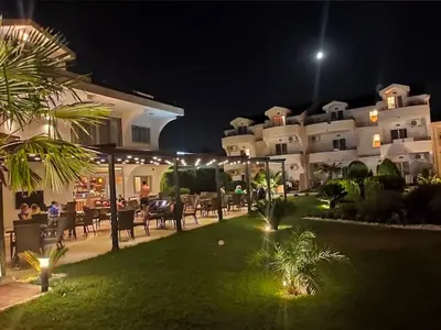 a resort yard with tables and chairs at night at Resort Comfort - Long Beach in Ulcinj