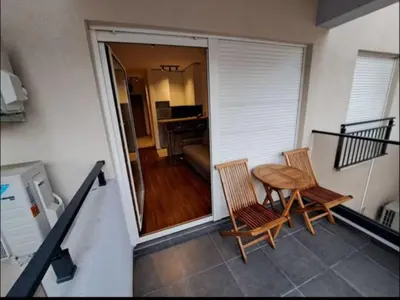 a balcony with a table and chairs and a living room at Master Quart studio apartment in Podgorica