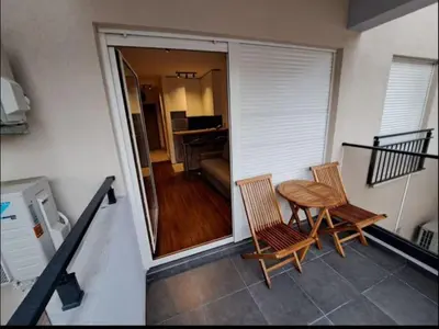a balcony with a table and chairs and a living room at Master Quart studio apartment in Podgorica