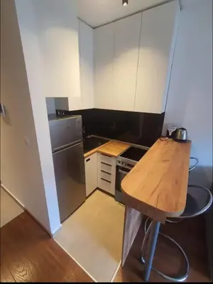 a small kitchen with a wooden table in it at Master Quart studio apartment in Podgorica