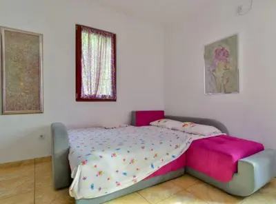 a bedroom with a bed with pink and white sheets at Villa Marković 2 in Sutomore