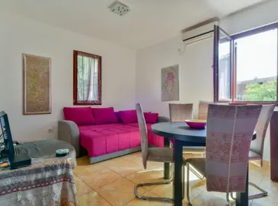 a living room with a pink couch and a table at Villa Marković 2 in Sutomore