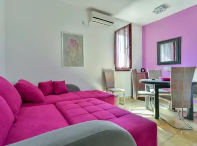 a living room with a purple couch and a table at Villa Marković 2 in Sutomore