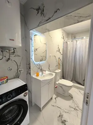 a bathroom with a toilet sink and a washing machine at Nar in Budva