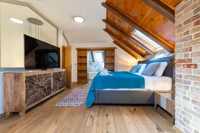 a bedroom with a large bed and a tv at Seafront Kotor Bay View Villa NW in Muo