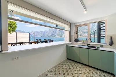 a kitchen with a large window and a view of the water at Seafront Kotor Bay View Villa NW in Muo
