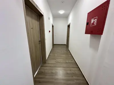 a corridor of an empty room with a door and wooden floors at Alula Apartments in Bar