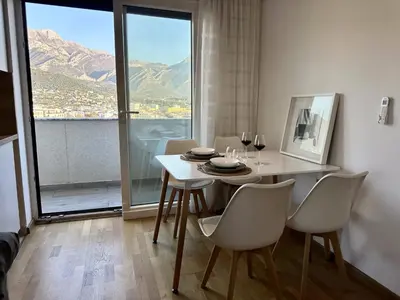 a dining room with a table and chairs and a window at Alula Apartments in Bar