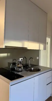 a kitchen with a sink and a stove and white cabinets at Sunny Villas Luxury Apartment with Garden and Seaview in Katun