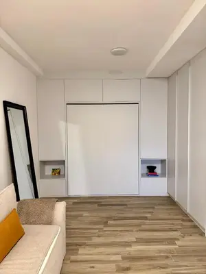 a living room with a couch and a large white door at Sunny Villas Luxury Apartment with Garden and Seaview in Katun