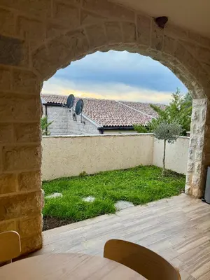 a view of a yard from a stone archway at Sunny Villas Luxury Apartment with Garden and Seaview in Katun