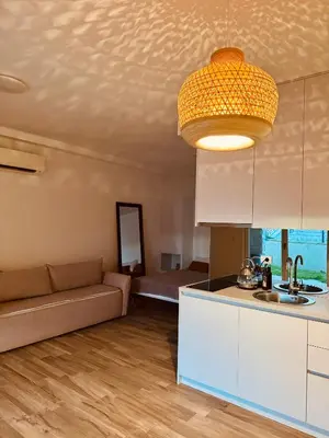 a living room with a couch and a kitchen at Sunny Villas Luxury Apartment with Garden and Seaview in Katun