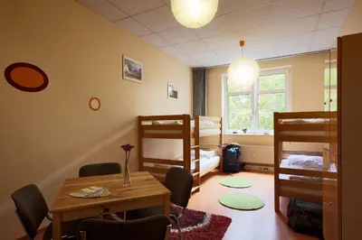 a room with a table and chairs and bunk beds at Parkside Place in Podgorica
