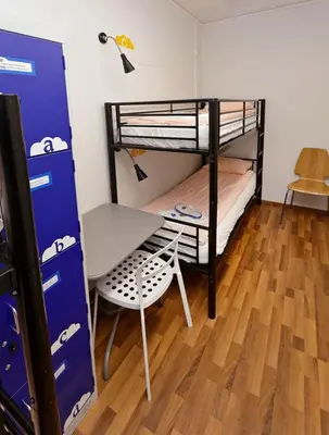 a room with two bunk beds and a table and a desk at Parkside Place in Podgorica