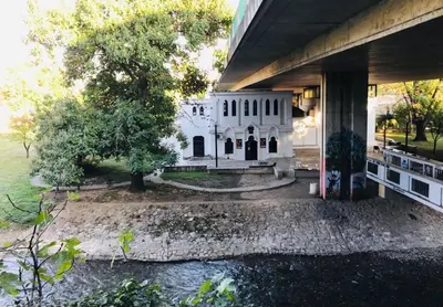 a white house sitting under a bridge at Parkside Place in Podgorica