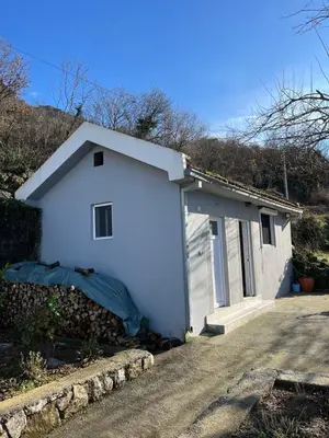 a small white garage with a driveway at Guest House Fenix