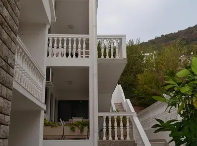 a white building with white stairs and plants at Guest House 4M Gregović in Petrovac na Moru