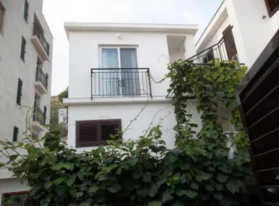 a white building with a window and a balcony at Guest House 4M Gregović in Petrovac na Moru