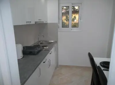 a small kitchen with a sink and a window at Guest House 4M Gregović in Petrovac na Moru