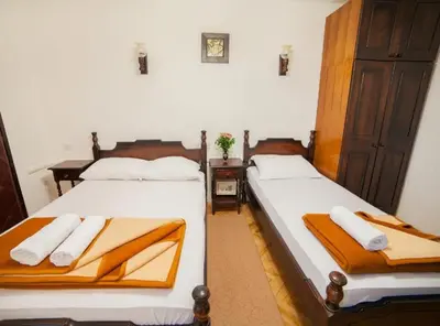 two beds in a hotel room with towels on them at Guest House 4M Gregović in Petrovac na Moru