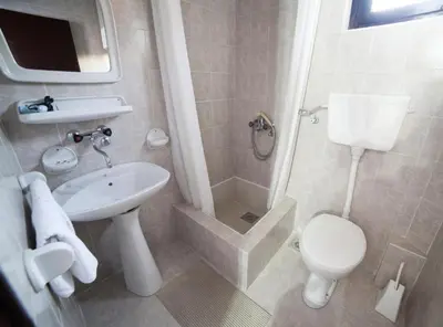 a bathroom with a toilet and a sink and a shower at Guest House 4M Gregović in Petrovac na Moru