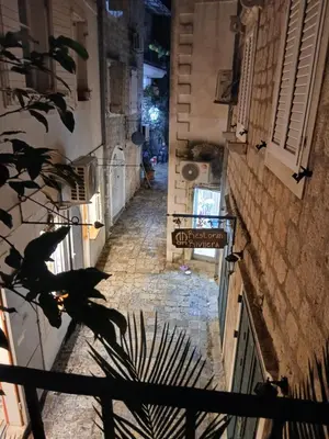 an alley with a sign on the side of a building at Old town nest in Budva