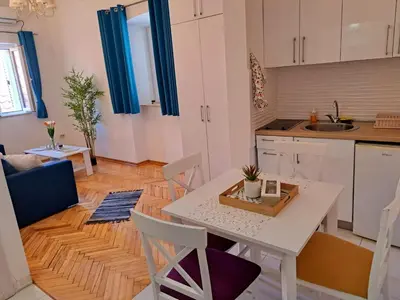 a kitchen and living room with a table and chairs at Old town nest in Budva