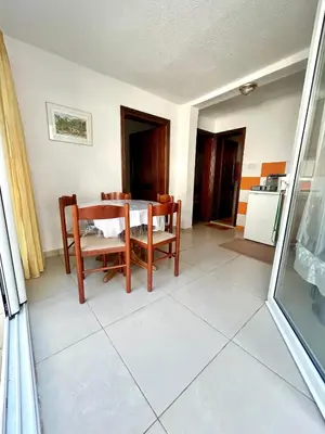 a kitchen and dining room with a table and chairs at Apartmane Đekovic in Ulcinj