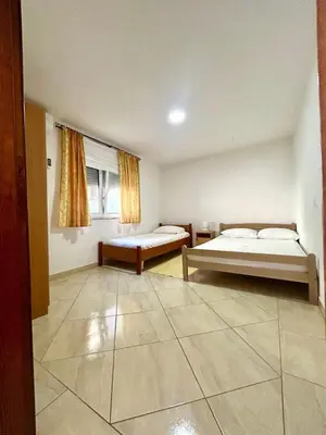 a room with two beds and a window in it at Apartmane Đekovic in Ulcinj